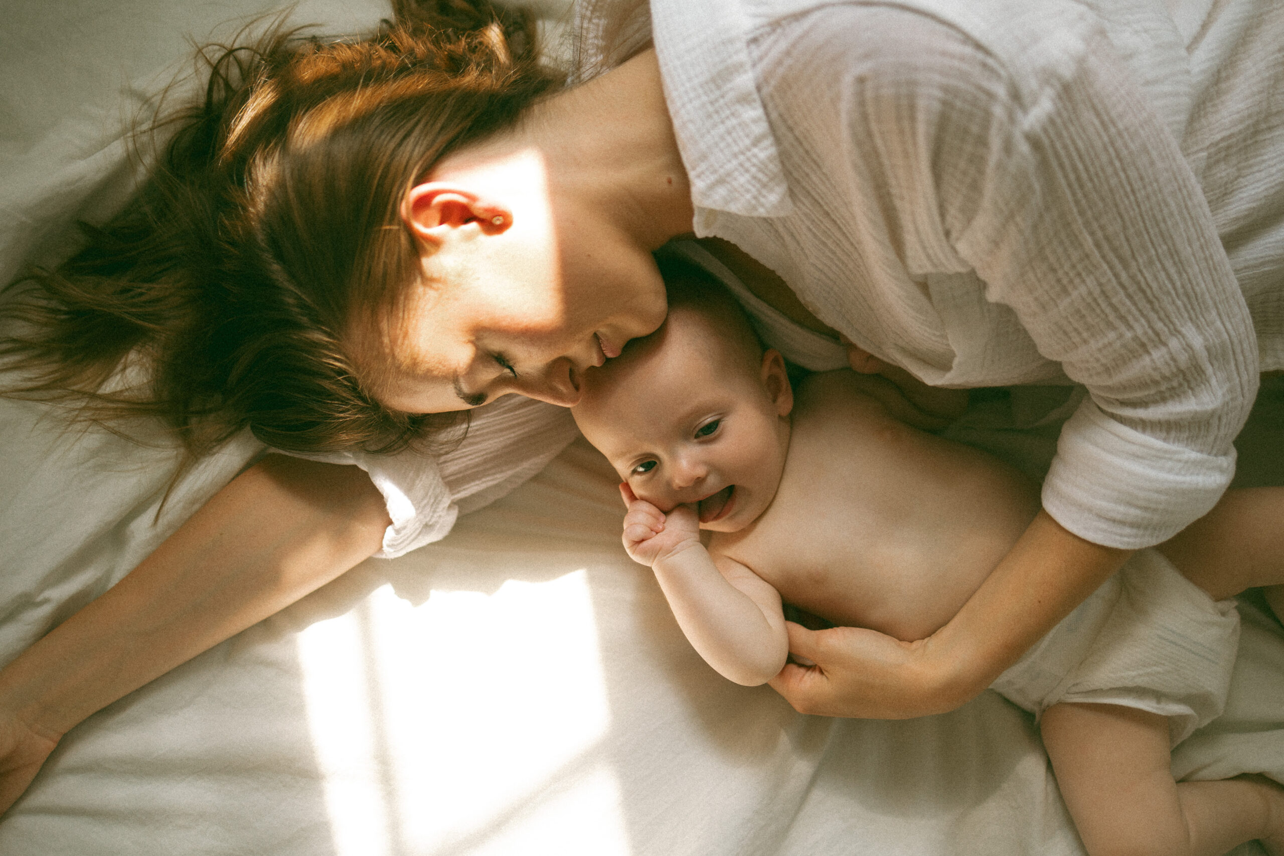 A loving mother holding her young child close, sharing a tender moment filled with joy and connection in a softly lit studio setting